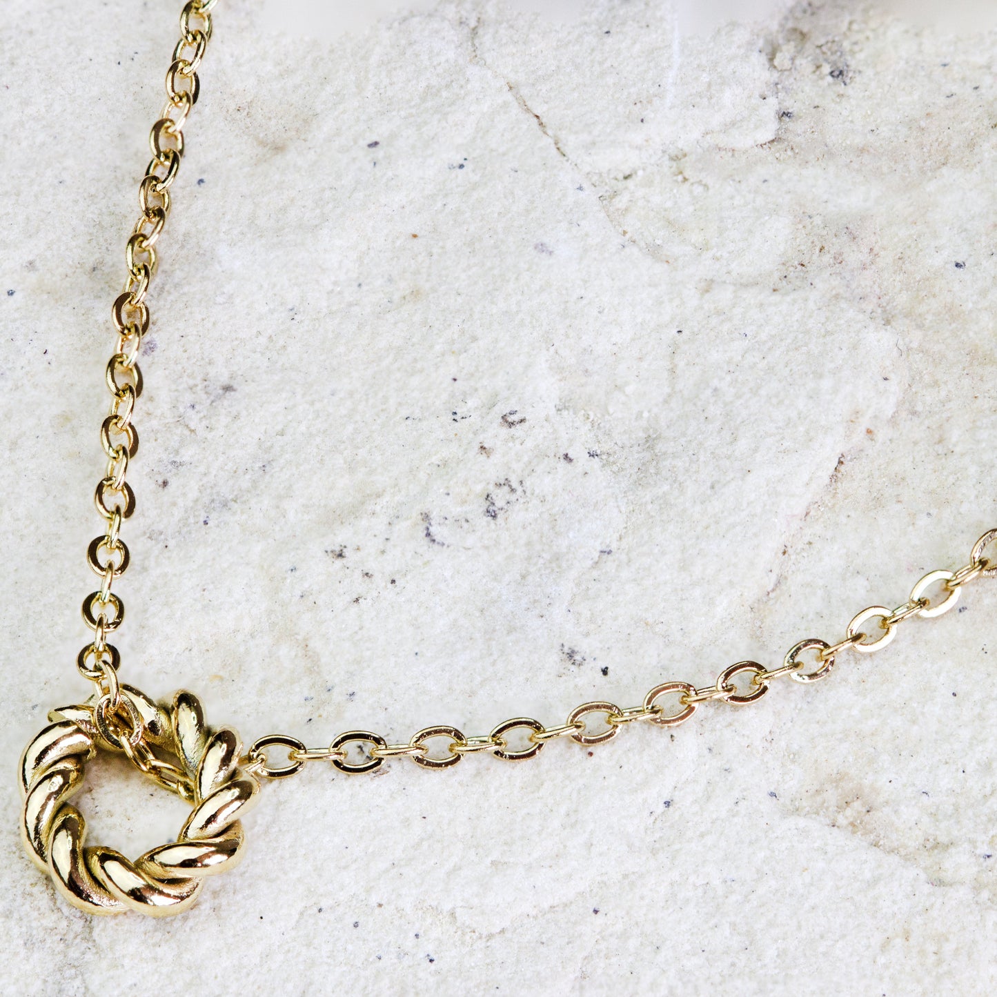 Delicate gold-plated necklace from Dahlia Jewels, featuring a lightweight chain with an intricate twisted ring charm at the center. This artistic piece combines traditional charm with a modern twist, ideal for adding an elegant focal point to any outfit. The charm’s detailed design captures light beautifully, making it a versatile accessory for both day and evening wear. Secures with a simple clasp. Available for free delivery in Nairobi. Keywords: jewellery, jewelry.