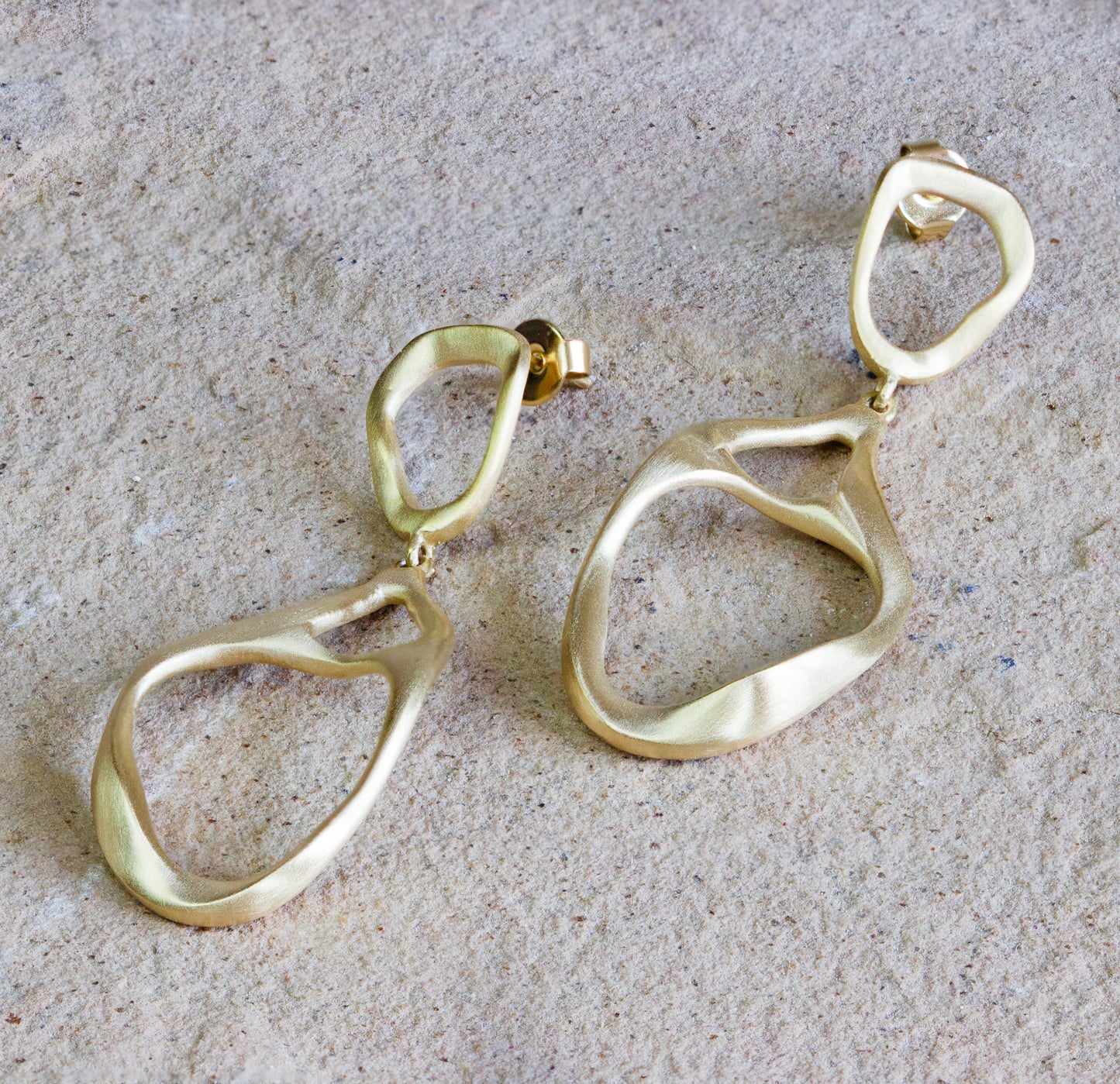 Stunning gold dangle earrings featuring an abstract, organic design with a smooth, matte finish. These elegant statement pieces are perfect for adding a contemporary touch to any outfit. Available with free delivery in Nairobi. #gorgeouseveryday