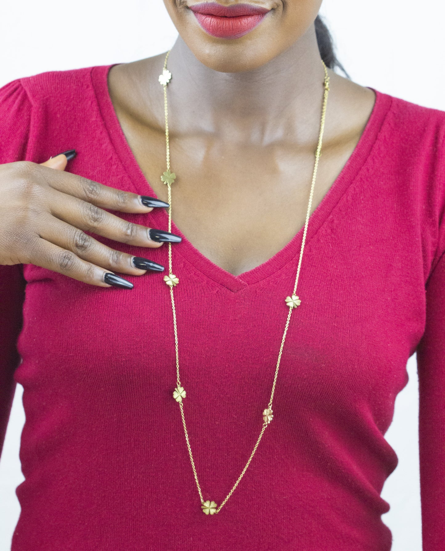Model's hand delicately holding a Dahlia Jewels' statement necklace, showcasing exquisite craftsmanship. Get yours with free jewellery delivery in Nairobi.