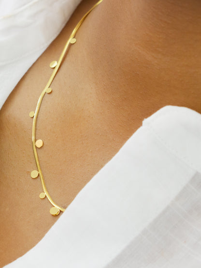 A model showcasing a delicate gold necklace with small round accents from Dahlia Jewels. The elegant and simple design enhances the beauty of the necklace. Dahlia Jewels offers free delivery in Nairobi.