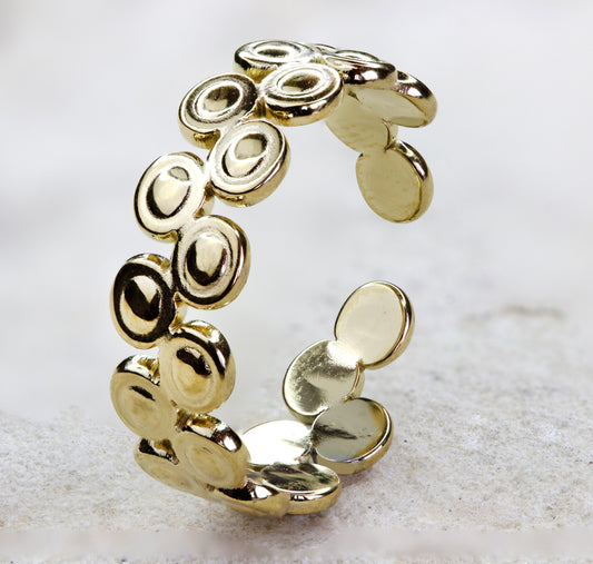 Close-up of a unique gold-plated ring from Dahlia Jewels, featuring a spiral design with multiple overlapping circles that create a harmonious, organic look. Each circle is outlined in a thin, dark groove that accentuates the gleaming gold finish. This elegant piece exemplifies Dahlia Jewels' commitment to combining natural inspiration with luxury. Available for free delivery in Nairobi. 