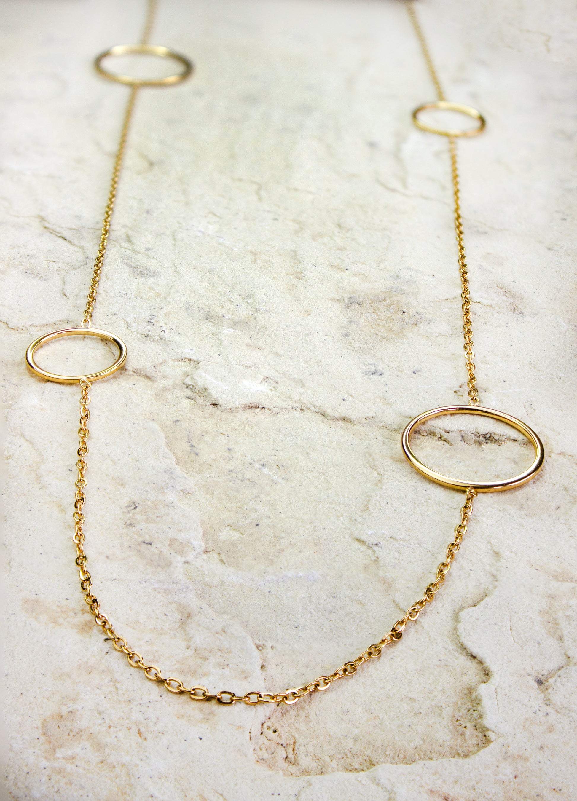 Elegant long gold-plated necklace from Dahlia Jewels, featuring three large open circle charms spaced along its slender chain. This contemporary design marries simplicity with sophistication, ideal for enhancing any outfit with a touch of sleek, modern style. The circles’ clean lines and polished finish reflect a minimalist aesthetic, making it a versatile choice for both casual and formal occasions. Secures with a standard clasp. Available for free delivery in Nairobi. Keywords: jewellery, jewelry.