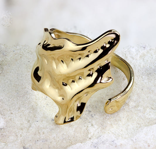 Sculptural gold-plated ring from Dahlia Jewels, featuring an avant-garde, organic design with textured, undulating surfaces and cut-out details that create a dramatic, eye-catching effect. This bold piece mirrors natural forms with a modern twist, perfect for making a statement. Its open-ended band allows for adjustable sizing, ensuring a comfortable fit for various finger sizes. Available for free delivery in Nairobi. Keywords: jewellery, jewelry.