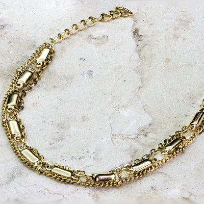Stunning multi-layered gold-plated bracelet from Dahlia Jewels, featuring a combination of different chain styles including classic links and delicate strands, interspersed with cylindrical charms for added texture and visual interest. This eclectic design makes a bold fashion statement, perfect for enhancing any outfit with a touch of glamour. Secures with a practical lobster clasp for a comfortable fit. Available for free delivery in Nairobi. Keywords: jewellery, jewelry.