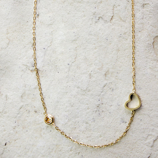 Elegant gold-plated necklace from Dahlia Jewels, featuring a delicate chain with a small, heart-shaped charm and a single zircon gemstone for a subtle touch of sparkle. This minimalist design is perfect for everyday wear or as a thoughtful gift, blending simplicity with a hint of luxury. Secures with a classic lobster clasp, ensuring a comfortable and adjustable fit. Available for free delivery in Nairobi. Keywords: jewellery, jewelry.