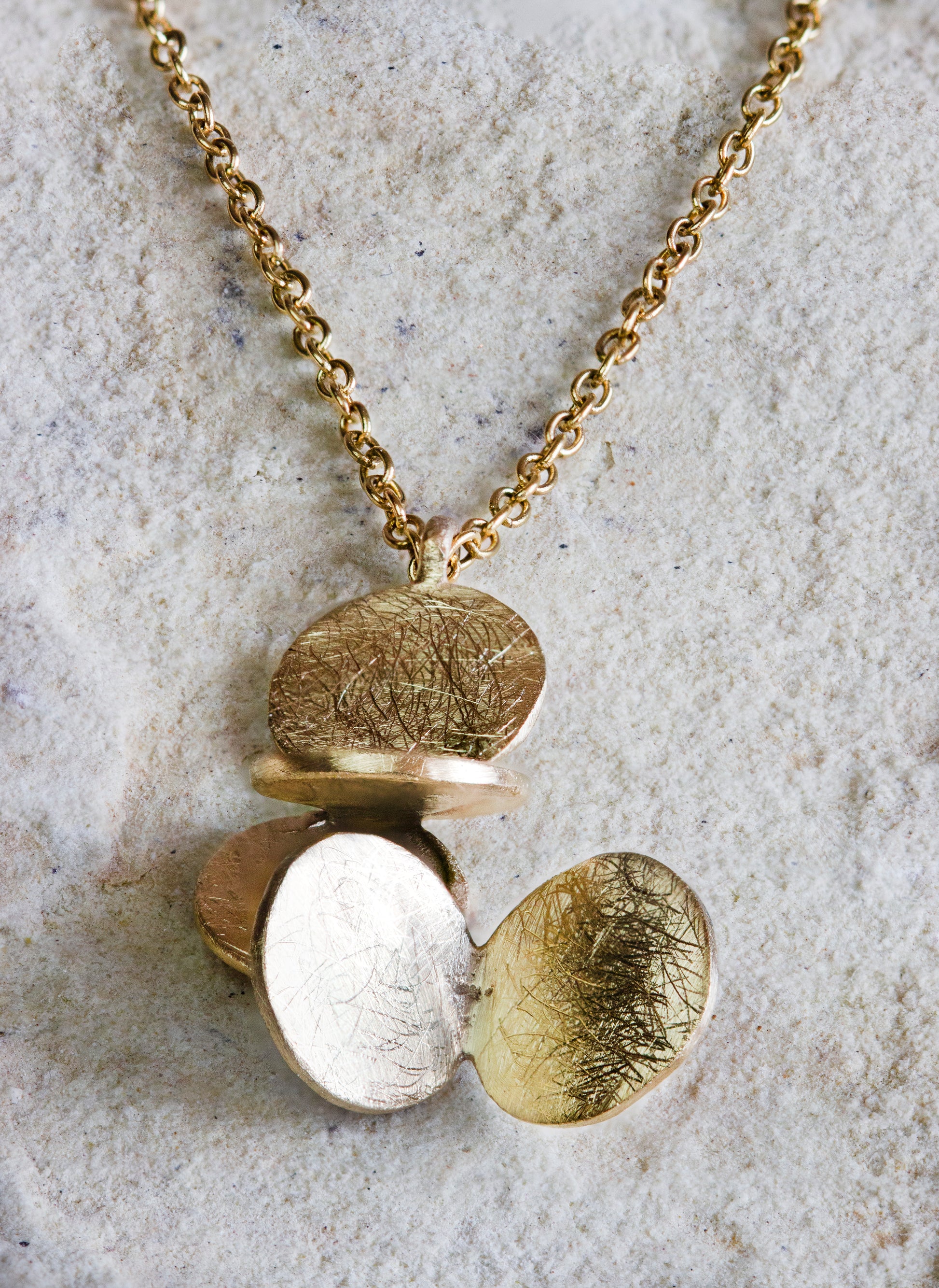 Elegant gold necklace featuring a cluster of textured, overlapping oval discs with a unique scratched finish. This stylish pendant offers a contemporary look, perfect for enhancing any outfit. Available with free delivery in Nairobi. #gorgeouseveryday