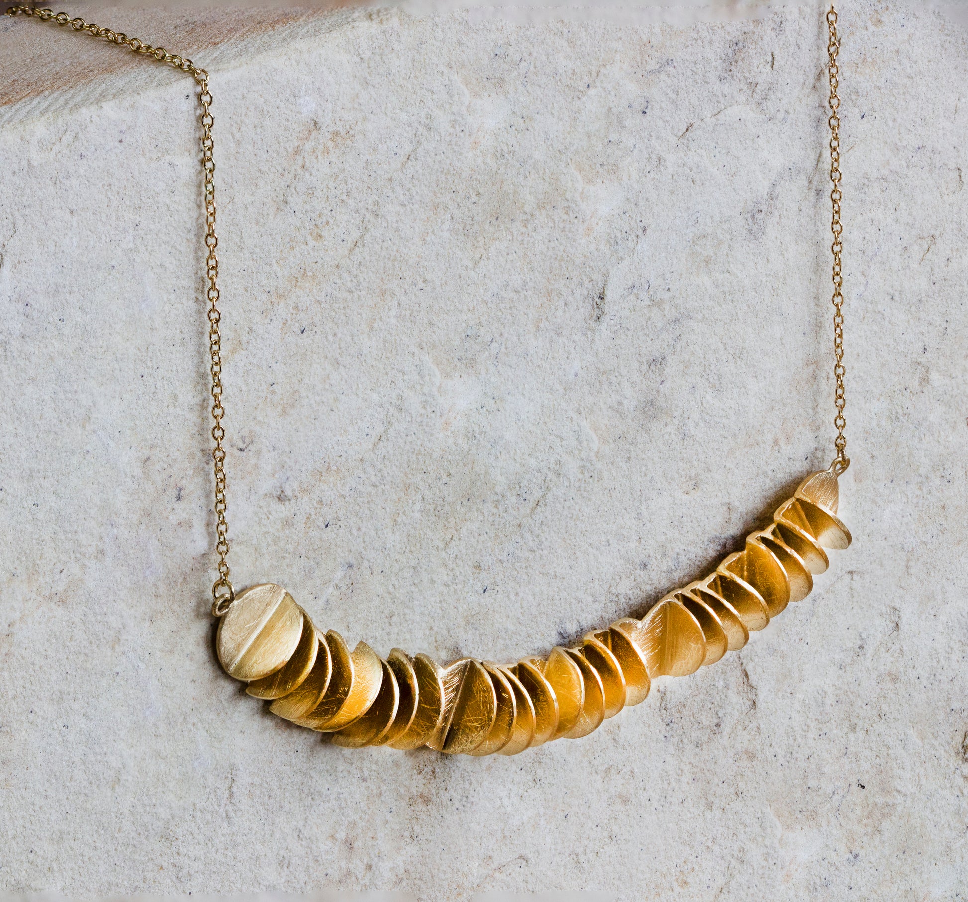 Stylish gold necklace featuring a cascading row of textured, overlapping discs with a matte finish. This eye-catching piece adds a unique and contemporary touch to any ensemble. Available with free delivery in Nairobi. #gorgeouseveryday