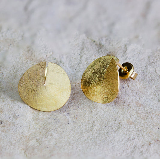 Artistic gold stud earrings featuring a textured, leaf-inspired design with intricate engraved details and a modern matte finish. These unique earrings add a touch of elegance and nature-inspired style to any outfit. Available with free delivery in Nairobi. #gorgeouseveryday