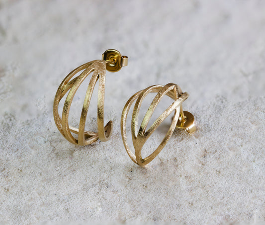 Elegant gold stud earrings featuring an open, cage-like design with a textured, matte finish. These unique and modern earrings add a touch of sophistication to any look. Available with free delivery in Nairobi. #gorgeouseveryday