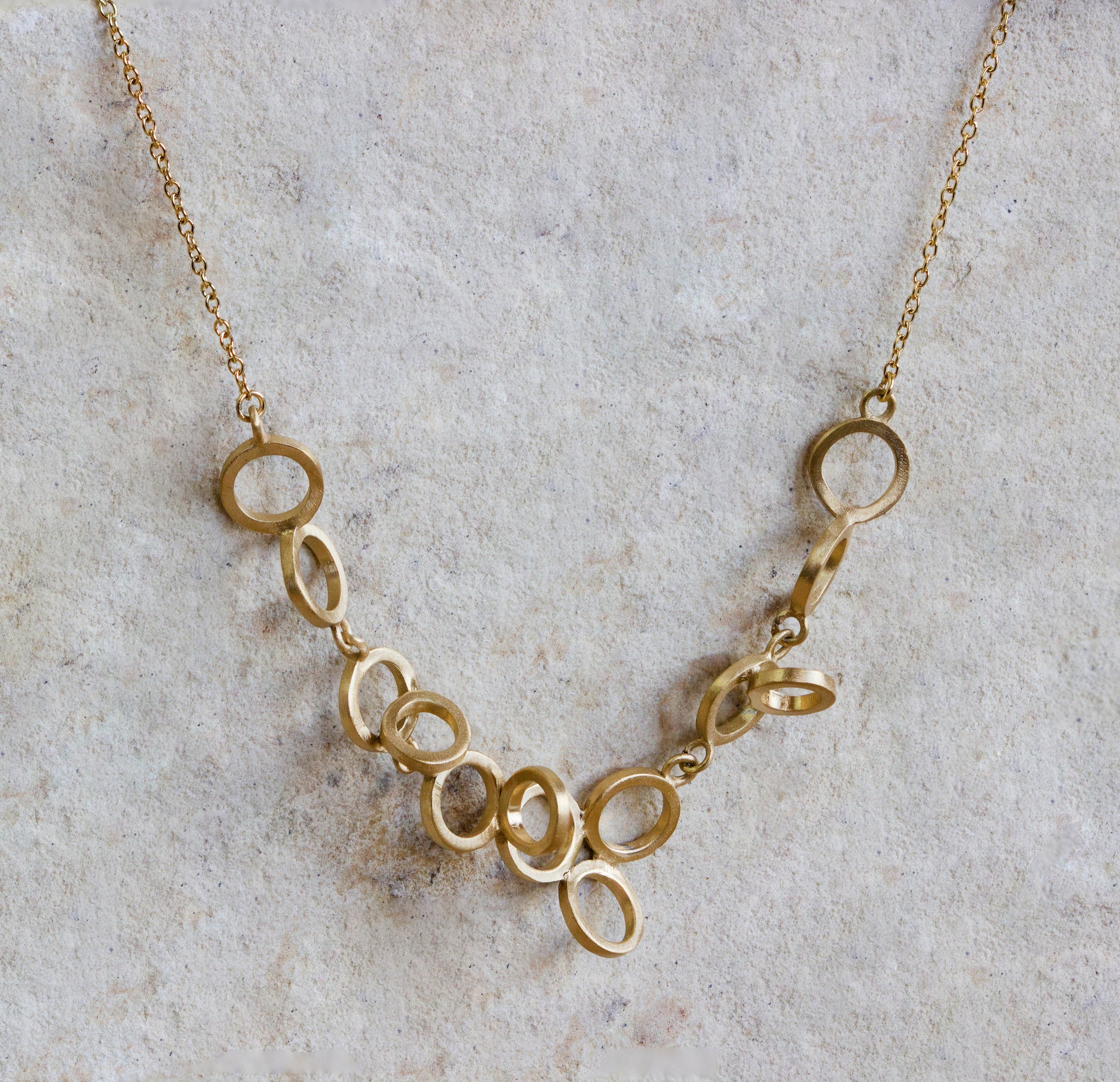 Chic gold necklace featuring a cascading arrangement of interlocking, open oval links with a smooth, matte finish. This stylish piece offers a modern and minimalist look, perfect for any occasion. Available with free delivery in Nairobi. #gorgeouseveryday