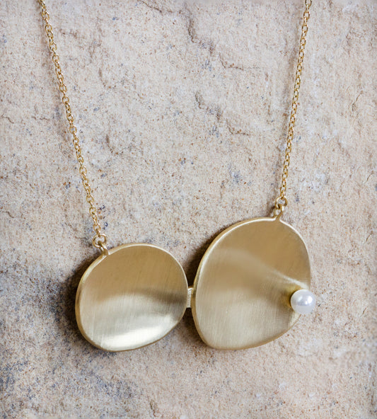 Elegant gold necklace featuring two overlapping oval pendants with a smooth, matte finish and a delicate pearl accent. This sophisticated piece offers a modern and minimalist look, perfect for any occasion. Available with free delivery in Nairobi. #gorgeouseveryday