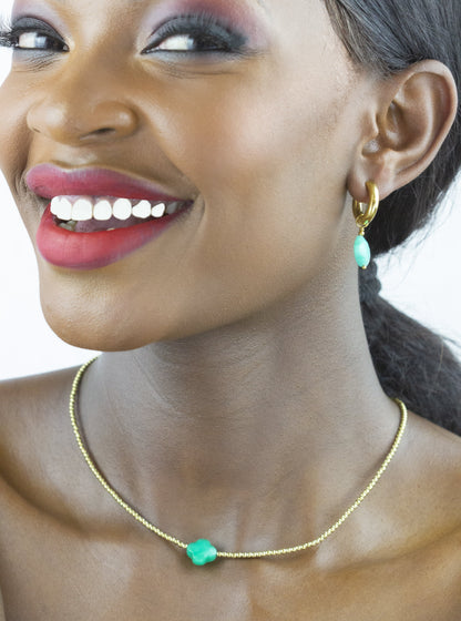 A model wearing Dahlia Jewels showcases a delicate gold necklace with bright bead accents for a touch of playfulness. Free jewellery delivery in Nairobi.