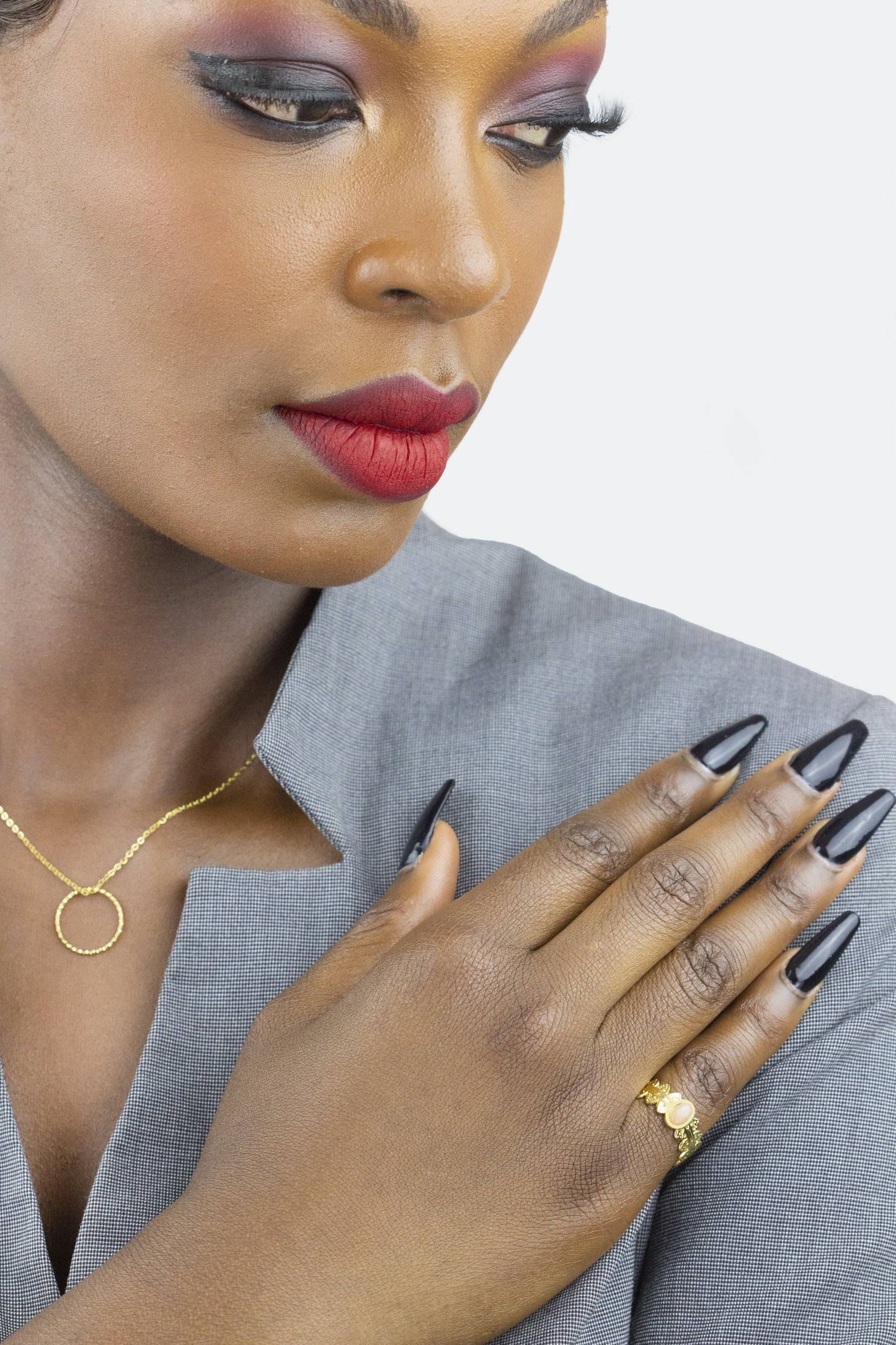 This close-up captures a model donning a Dahlia Jewels' delicate chain necklace with a circular pendant, matched with a chic golden ring. Free delivery in Nairobi.
