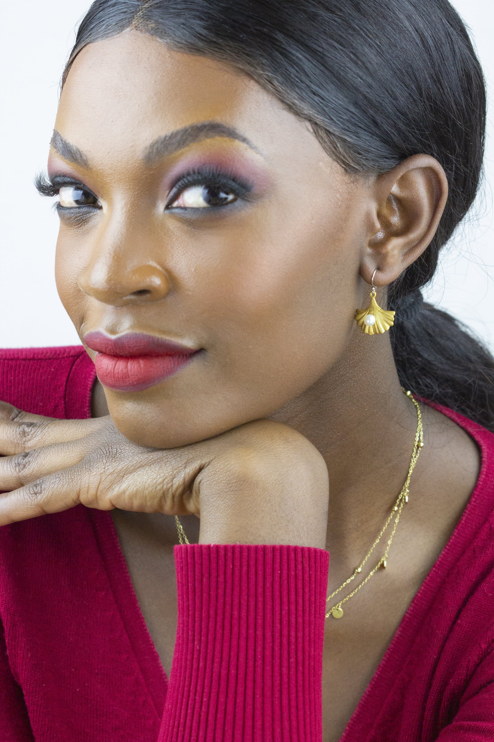 Dahlia Jewels presents a model wearing golden petal earrings, adding a dash of elegance to the vibrant red attire. This piece is perfect for a radiant daytime look. Benefit from free delivery in Nairobi and adorn yourself with fine jewelry from Dahlia Jewels.