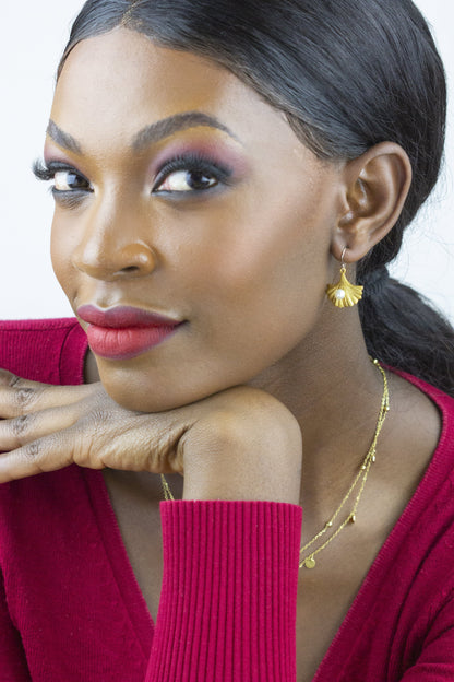 Dahlia Jewels presents a model wearing golden petal earrings, adding a dash of elegance to the vibrant red attire. This piece is perfect for a radiant daytime look. Benefit from free delivery in Nairobi and adorn yourself with fine jewelry from Dahlia Jewels.